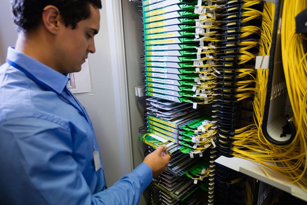 Technician managing fiber optic distribution equipment